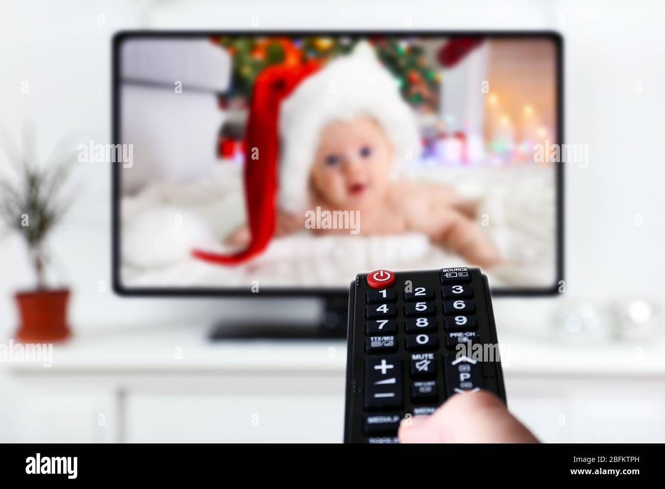 Remote Controls In Front Of Lit Christmas Tree Stock Photo - Download Image  Now - Christmas, Television Set, Remote Control - iStock