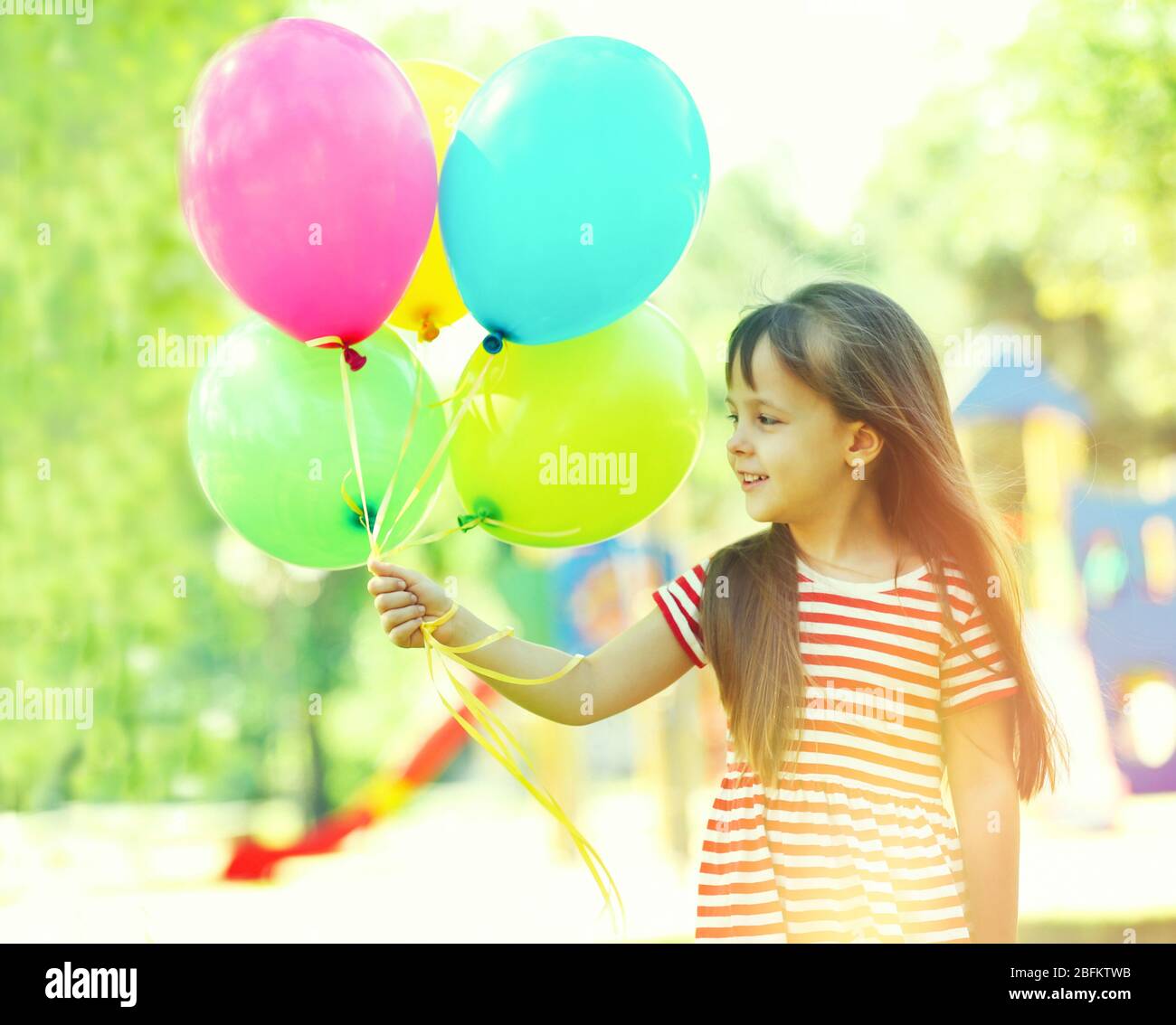 Little girl with balloons in the park Stock Photo - Alamy
