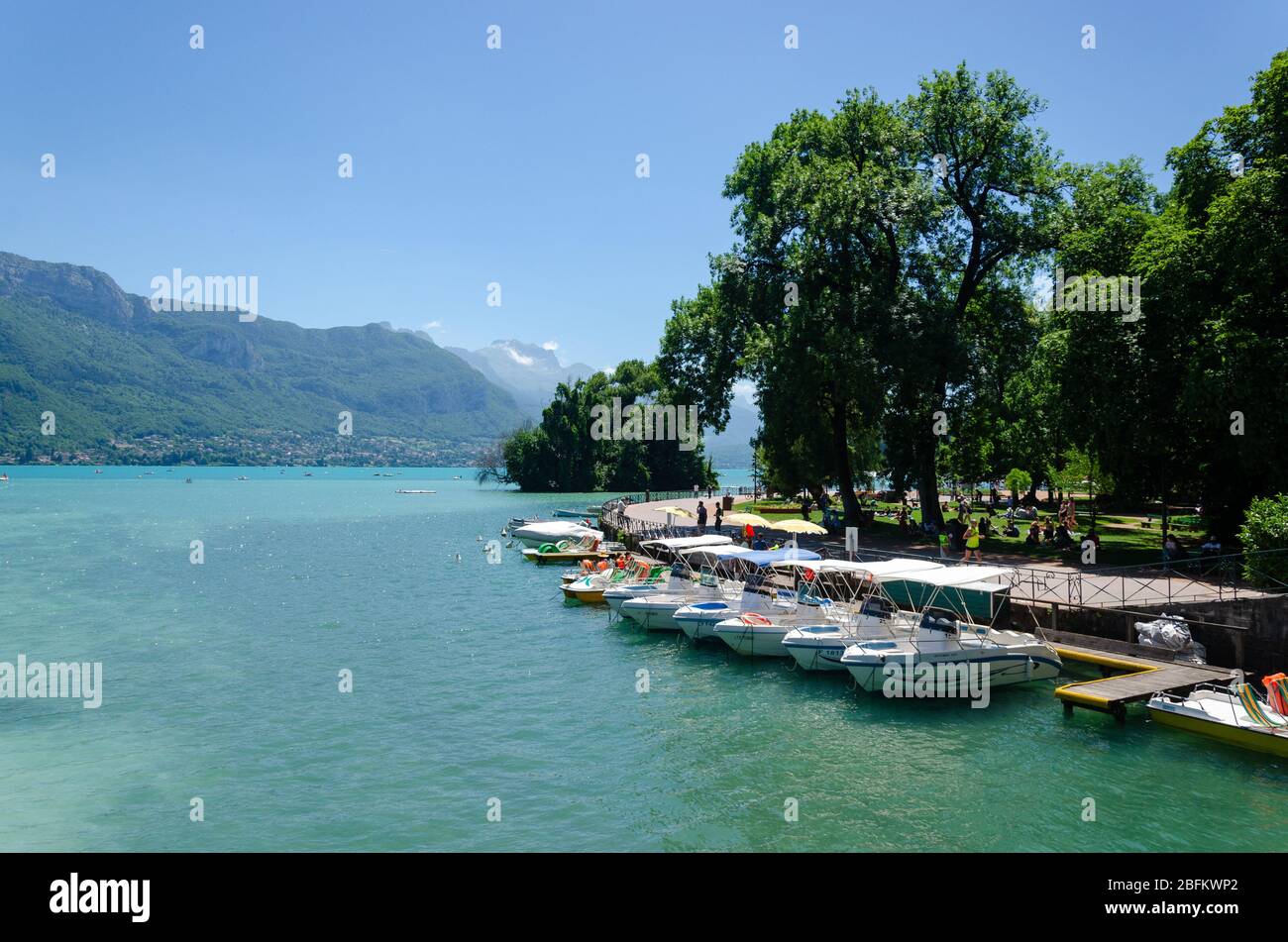 Boats available for rent anchored on the shores of Lake Annecy in