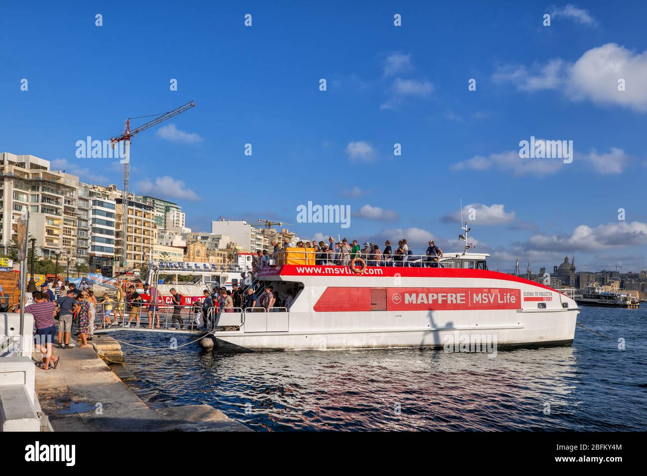 Valletta, Malta - October 13, 2019: Group of people leaving Ferry boat at Sliema town waterfront, public transport in Marsamxett Harbour between Sliem Stock Photo
