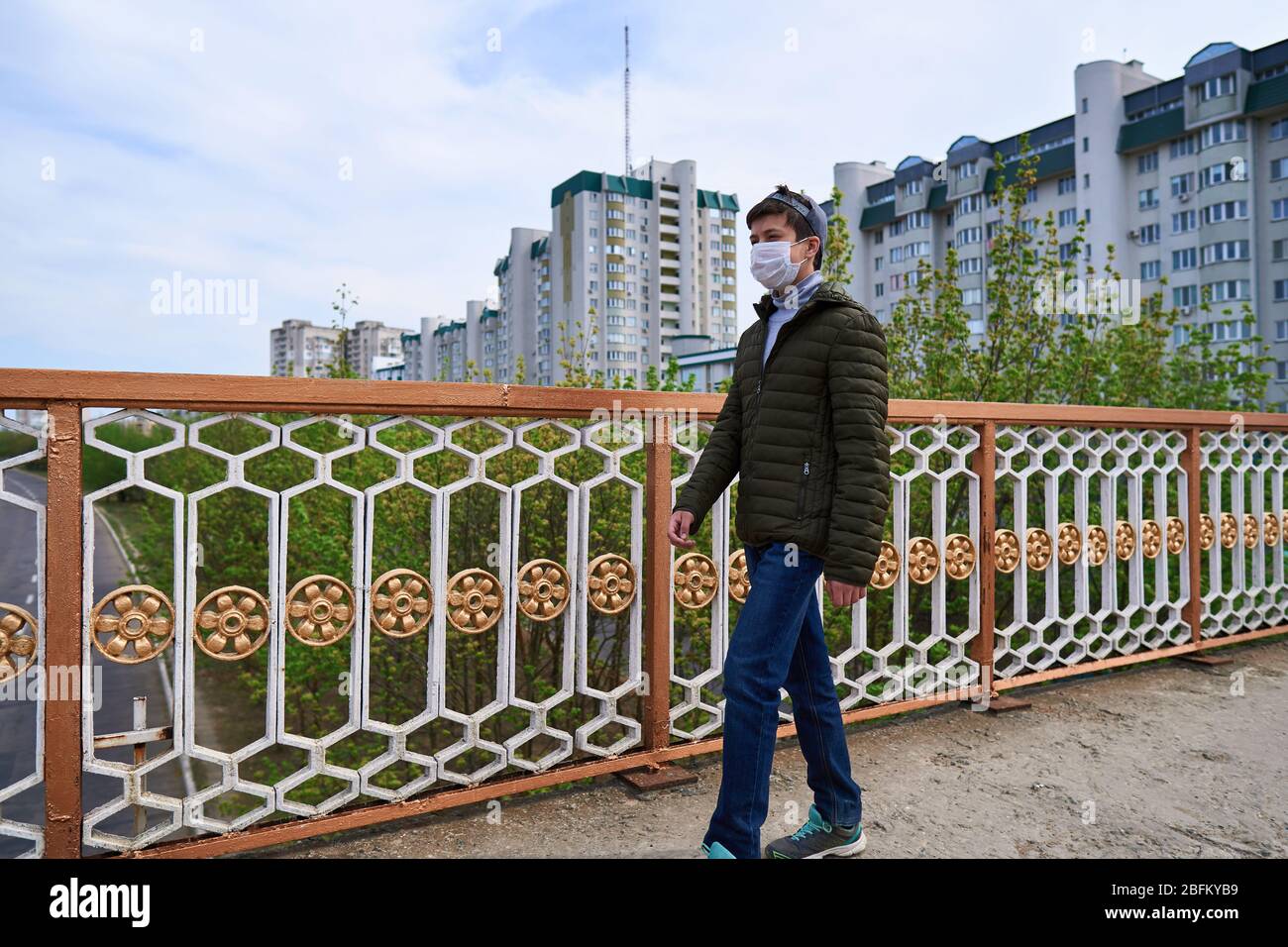 Image showcasing teen boy walks down the street during the day, a pedestrian walkway and ...