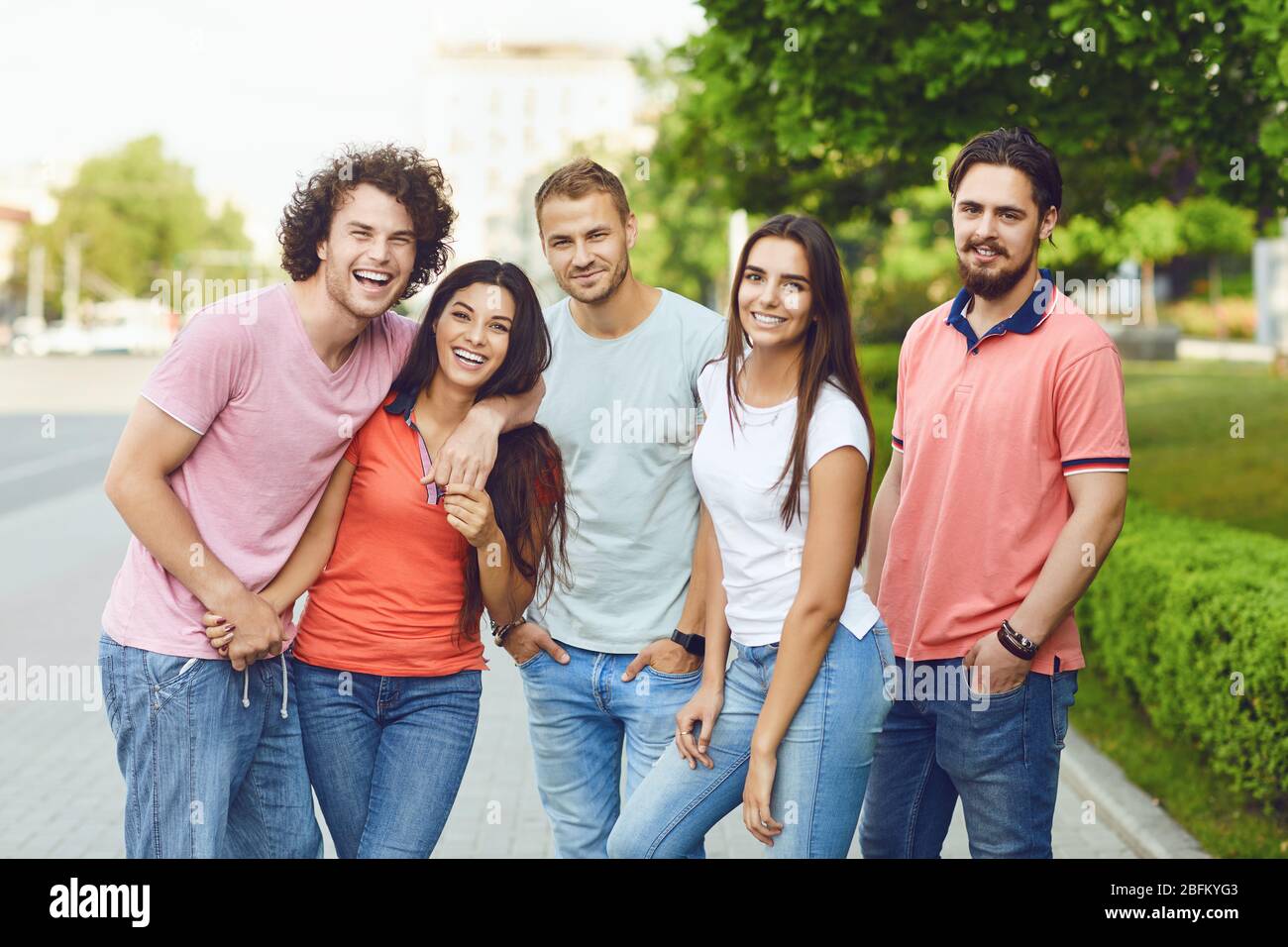 Group of people smiling on a city street in summer. Stock Photo