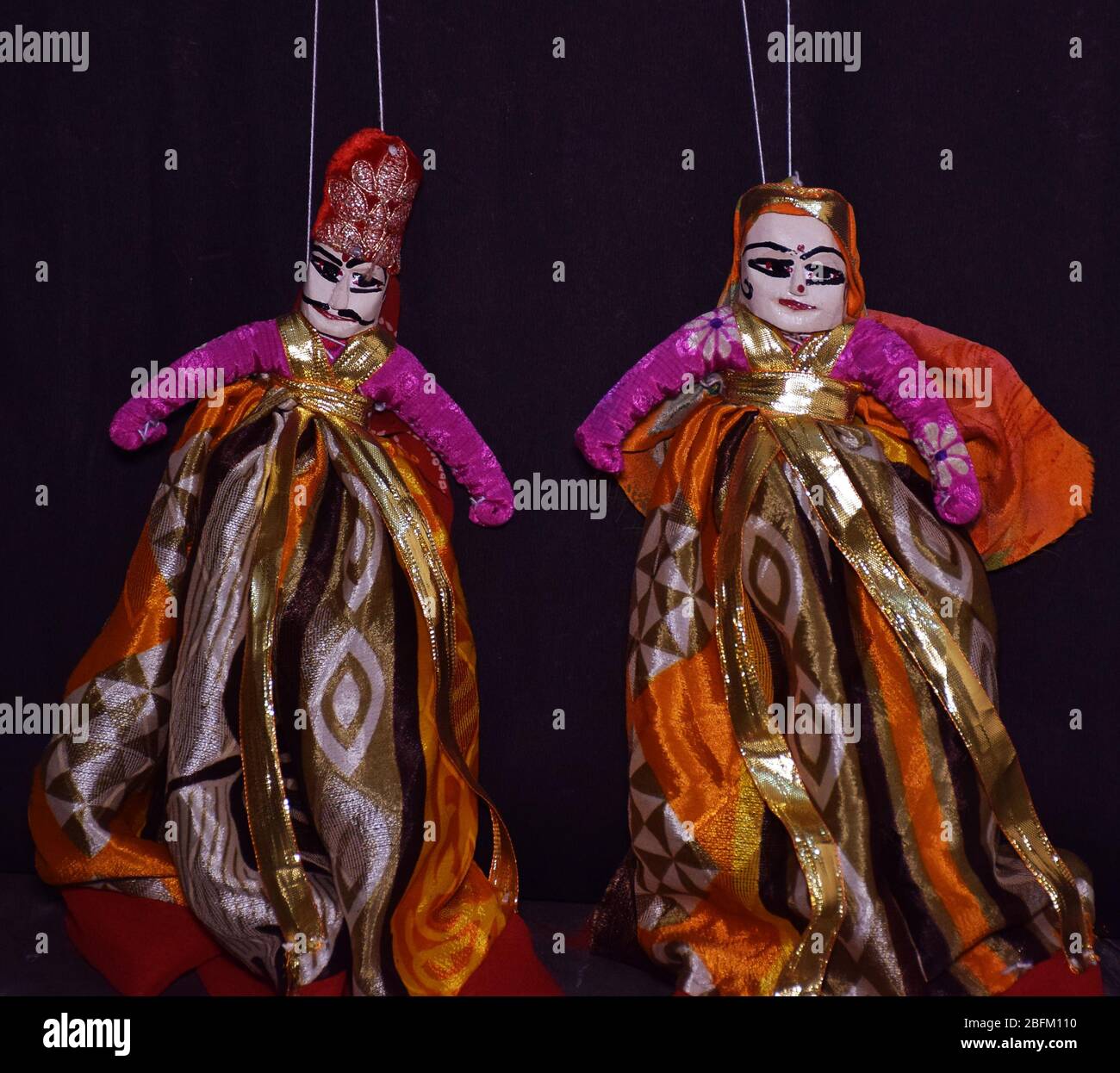Rajasthani Kathputli or Puppets isolated on a dark background. Indian Rajasthan wooden Puppets are also referred as Kathputli in Hindi Language Stock Photo