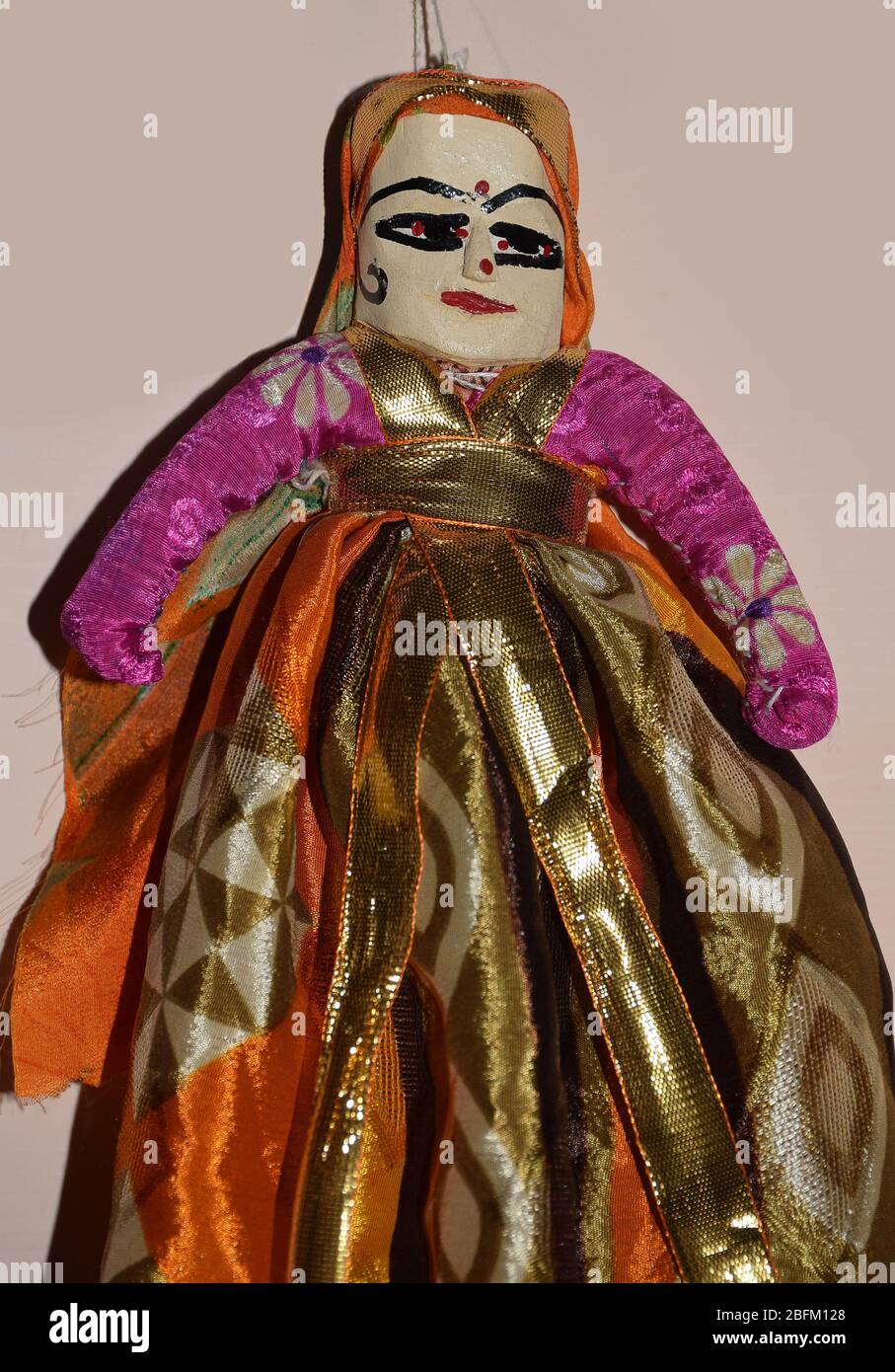 Rajasthani Female Doll Puppet or Kathputli attached from string is isolated on a light background.  Rajasthan Indian Puppets are referred as Kathputli Stock Photo
