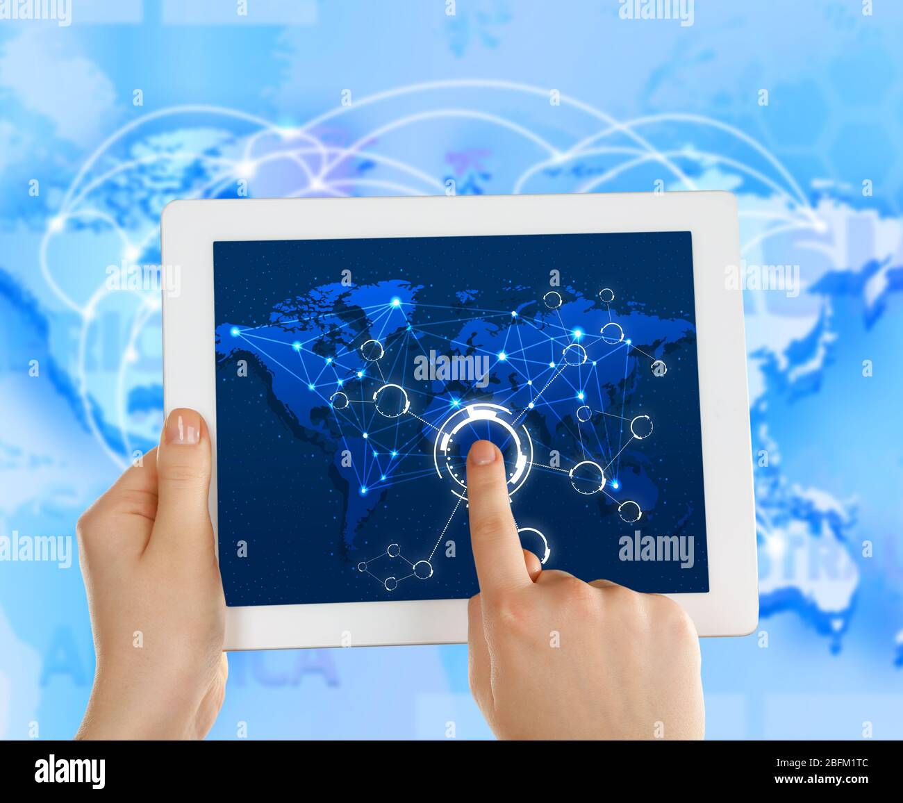 Close up of human hand touching screen of tablet pc with world map and network Stock Photo