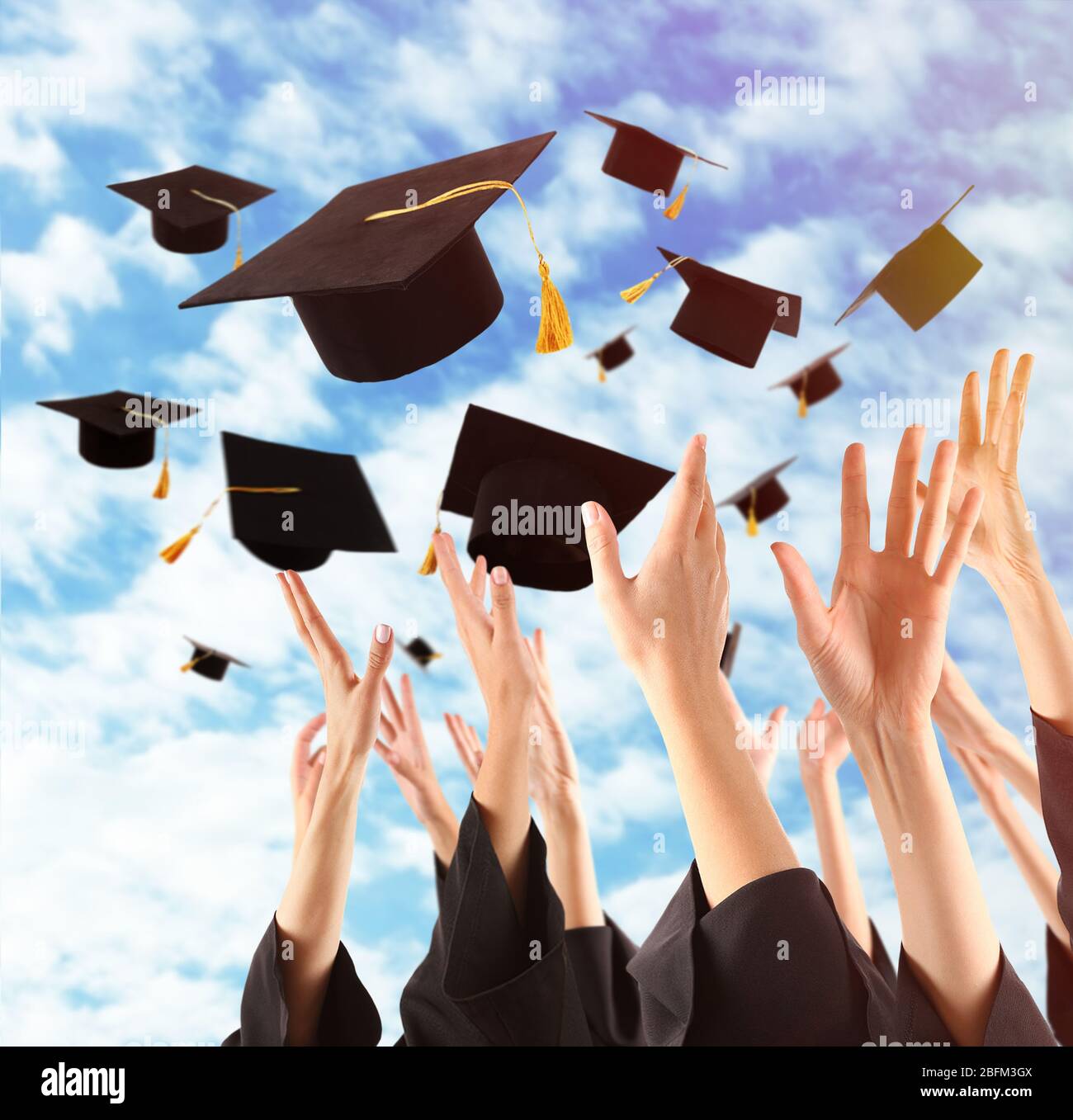 Graduates hands throwing graduation hats in the sky Stock Photo Alamy
