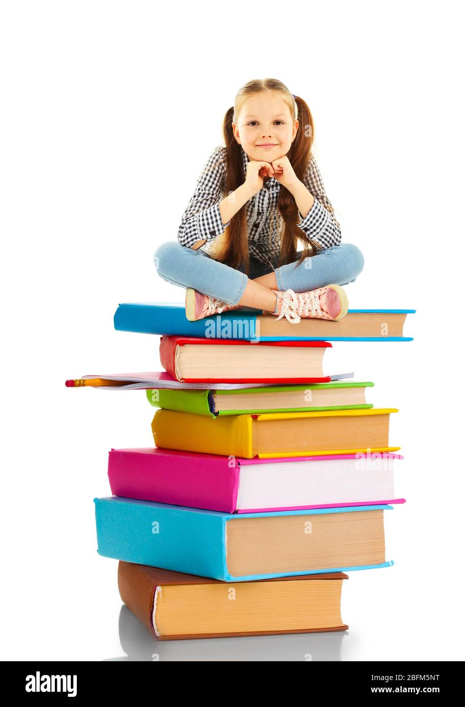 Cute little girl sitting on stack of books isolated on white Stock ...