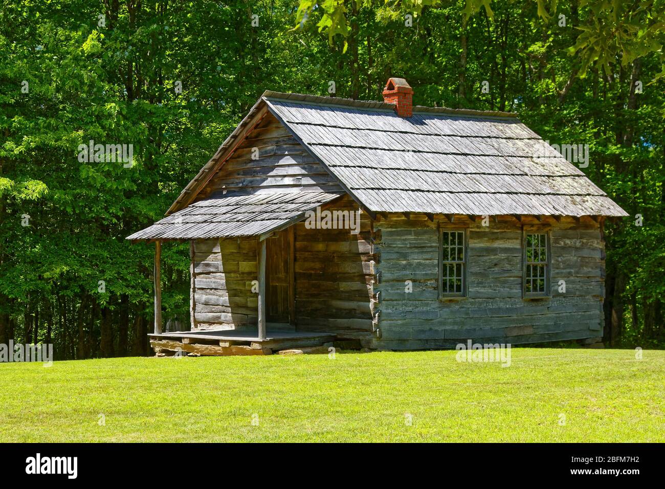 Brush Mountain Schoolhouse, one room; old log building; rough texture, green grass, trees, rural scene, education; learning; Hensley Settlement; Cumbe Stock Photo