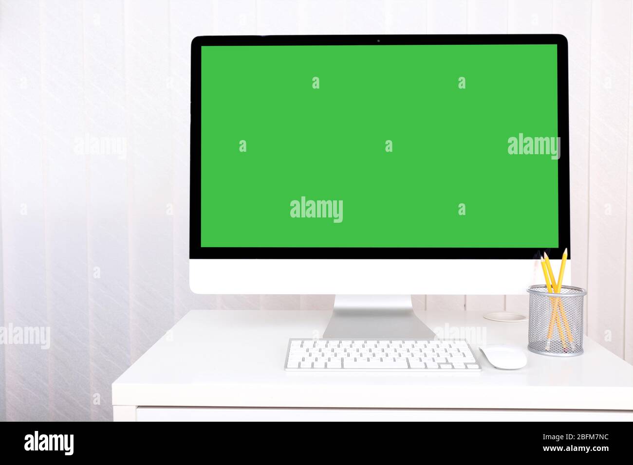 Modern computer with green screen, on table Stock Photo - Alamy