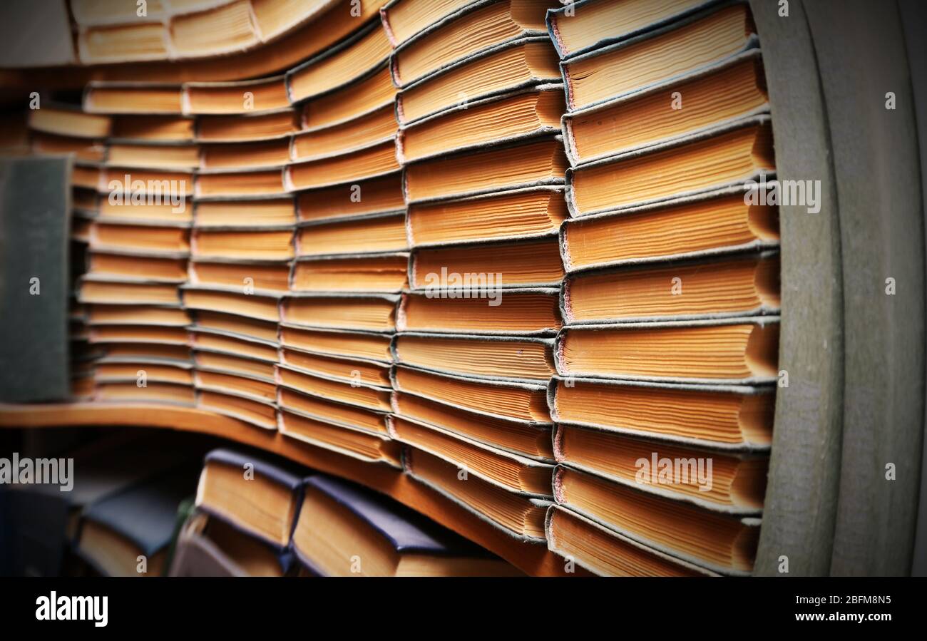 Many books on bookshelf in library, image with perspective distortion ...