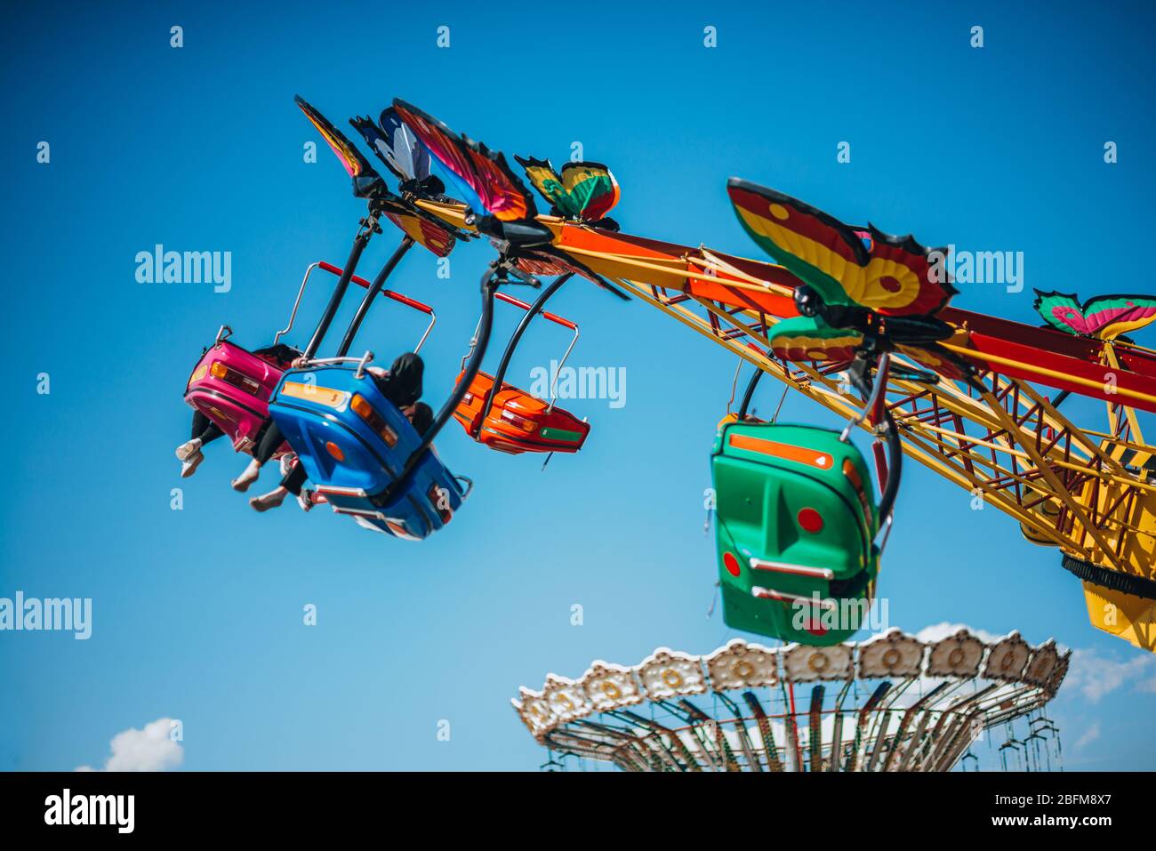 Vibrant seats of a roundabout swing ride at the local theme park Stock