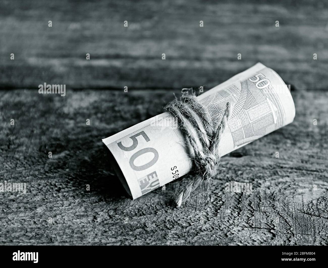 Roll of Euro banknotes on wooden background Stock Photo - Alamy