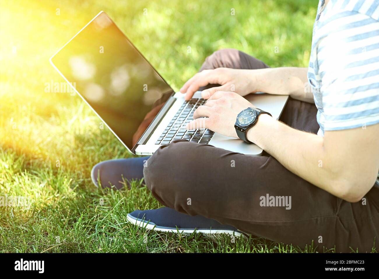 Young man holding laptop sun hi-res stock photography and images - Alamy