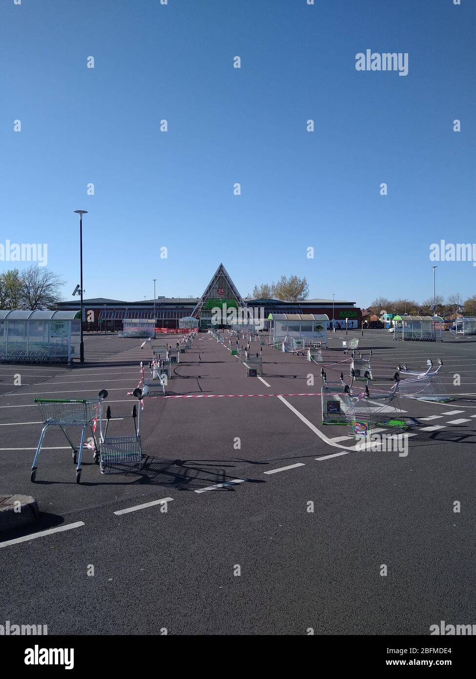 An ASDA supermarket in St Helens, UK uses a line of trolleys/carts in ...