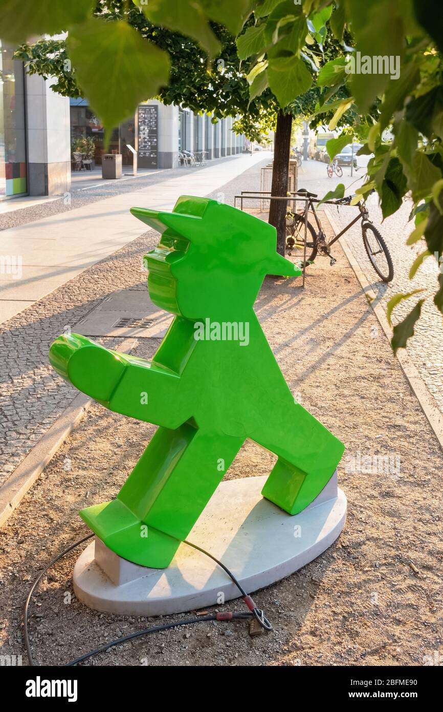 Statue of an ampelmann figure with Berlin tv tower at background at sunrise in Berlin Stock Photo