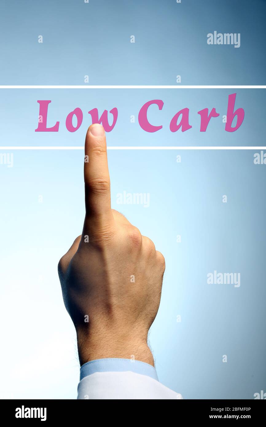 Doctor pointing on Low-Carb text on blue background Stock Photo