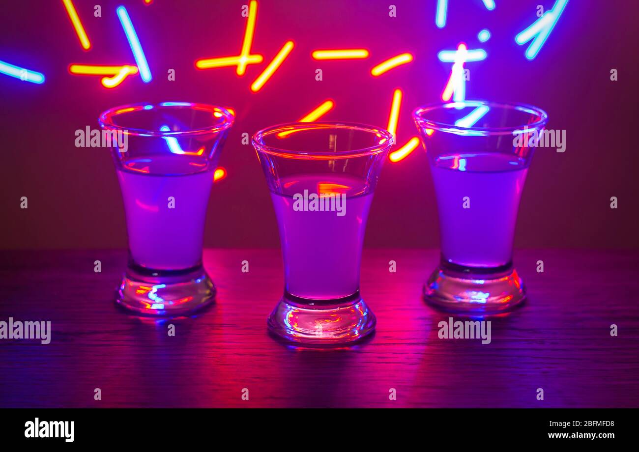 Three drinks at the party. Three shots with cocktails at the bar. Liquor,  vodka, fresh. Shining on a colored background. Night club, after the party  Stock Photo - Alamy