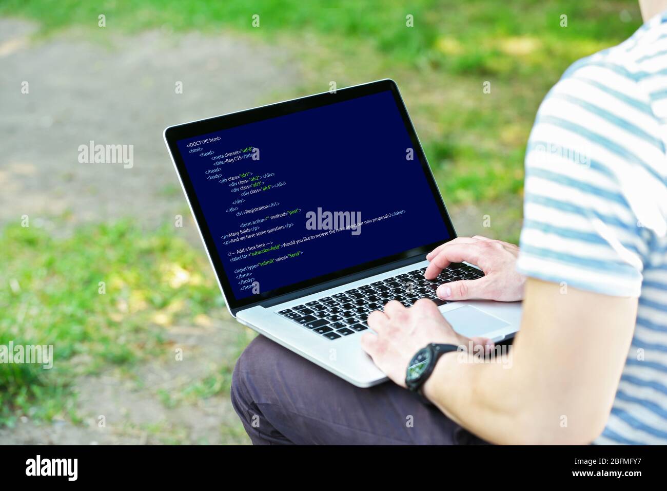 Man using laptop, writing programming code on laptop Stock Photo
