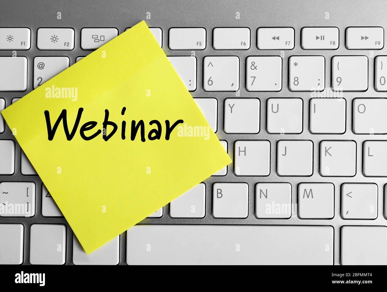 Webinar written on sticky note on laptop keyboard Stock Photo