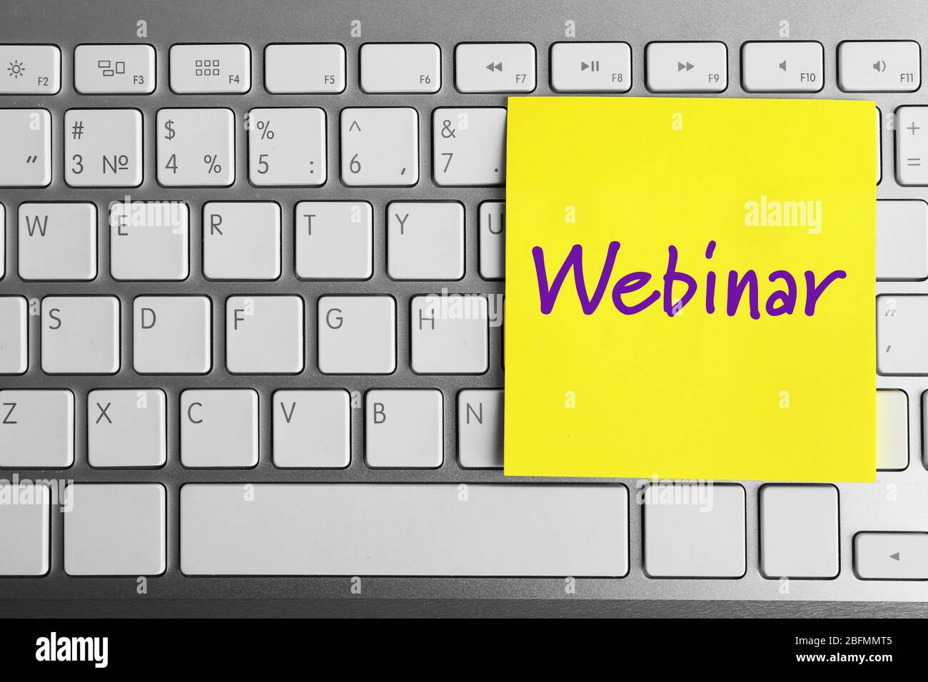 Webinar written on sticky note on laptop keyboard Stock Photo