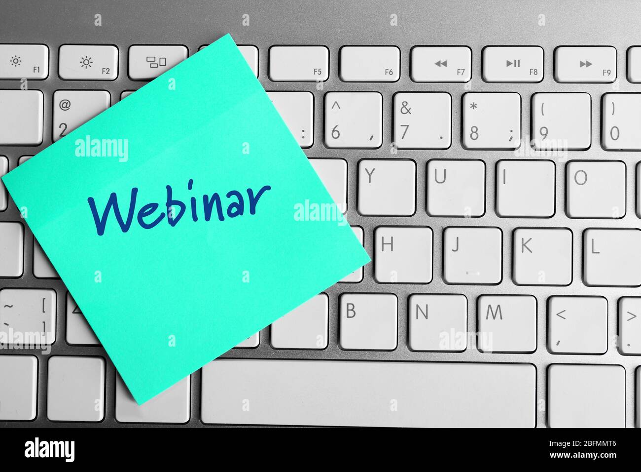 Webinar written on sticky note on laptop keyboard Stock Photo