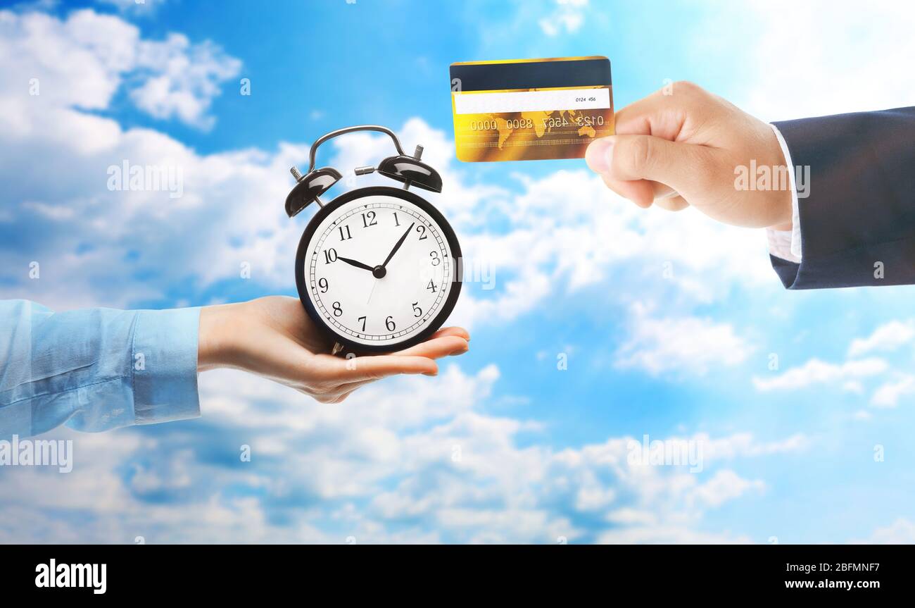 Time is money. Buying time. Hand with piggy bank and hand with alarm ...
