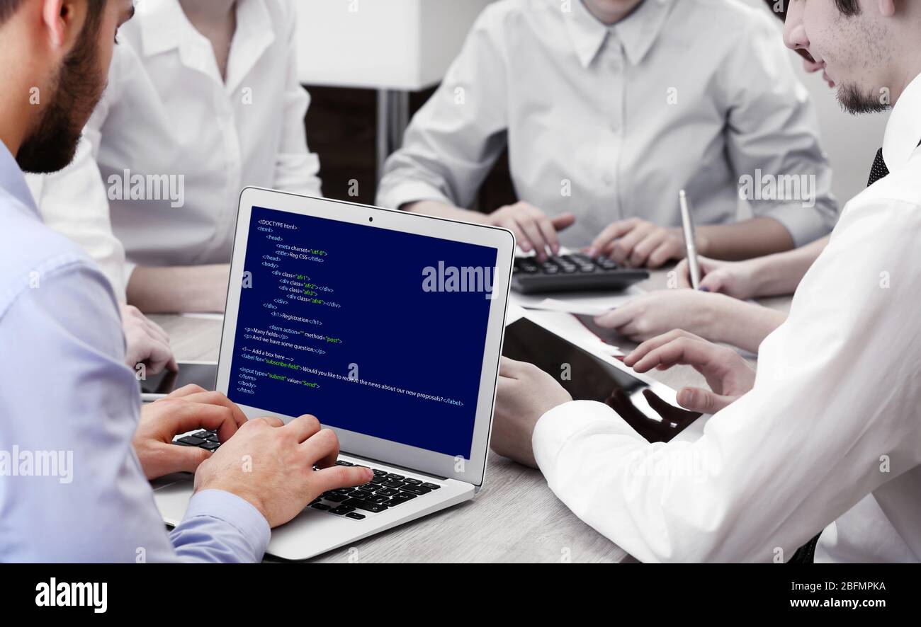 Man using laptop, writing programming code on laptop Stock Photo