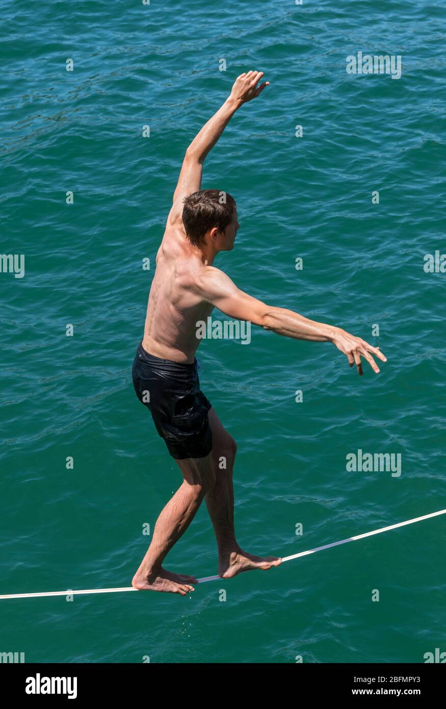 A tightrope walker entertaining tourists on Wellington waterfront promenade, Wellington, New Zealand Stock Photo
