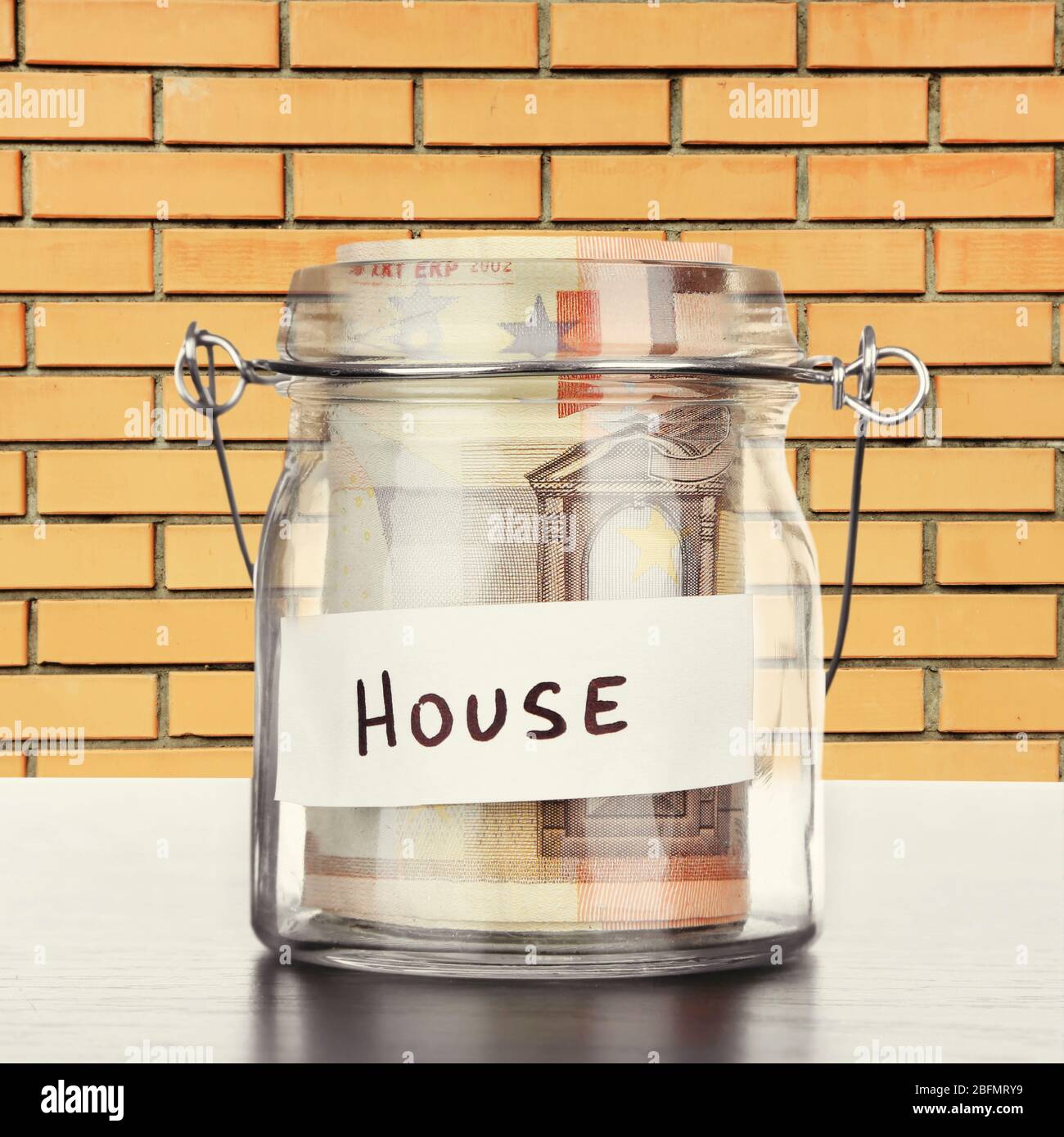 Jar for savings full of banknotes on wall background Stock Photo - Alamy