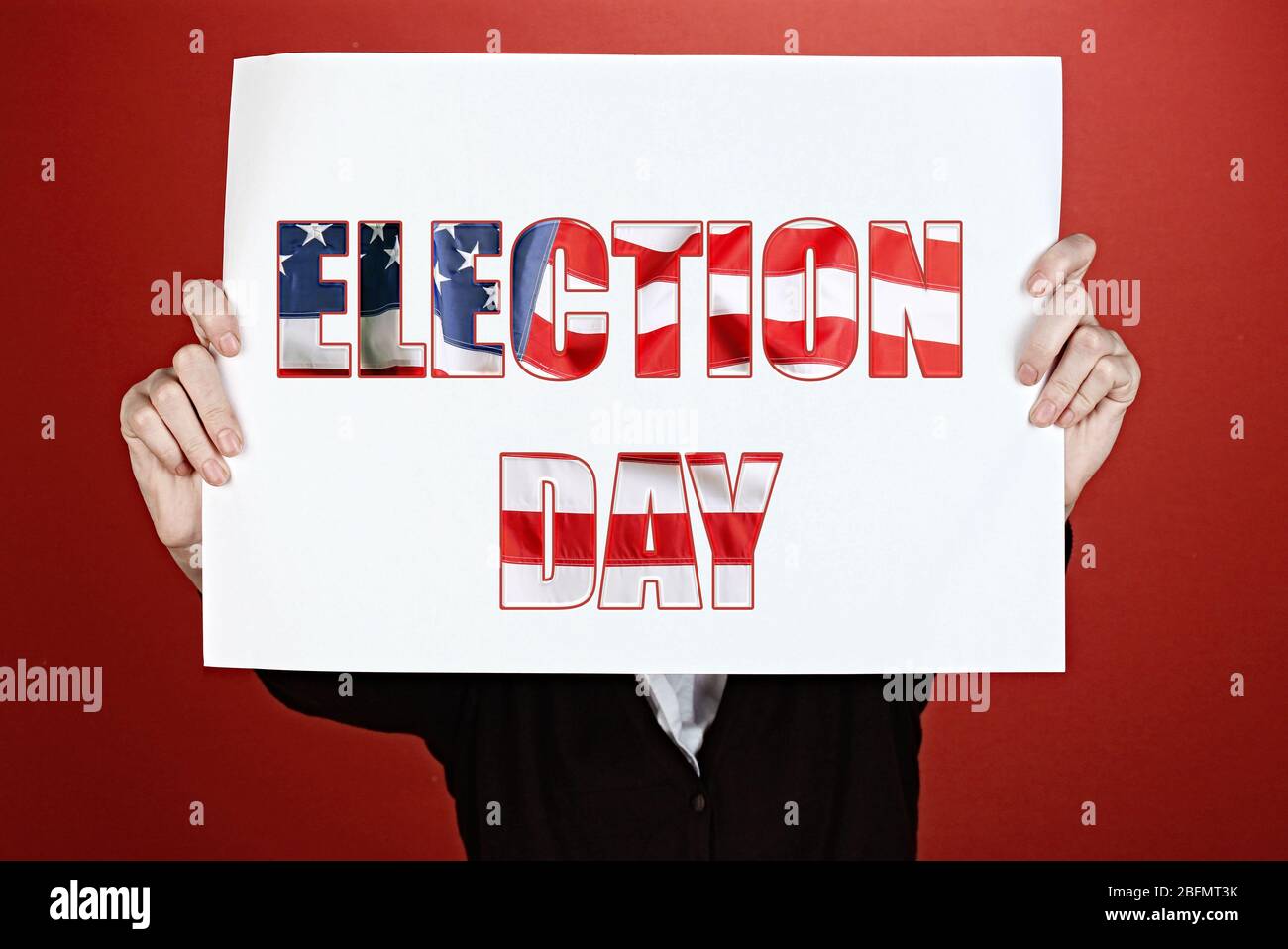 Woman holding paper with Election Day text on red background Stock Photo