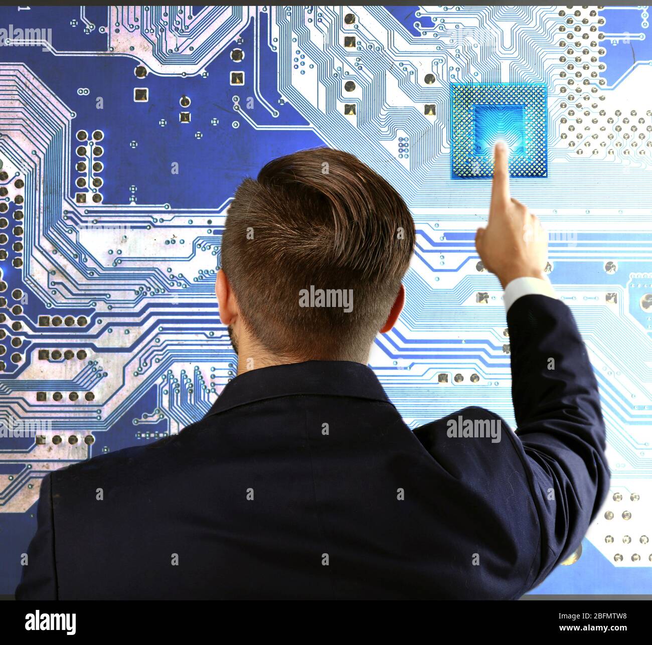 Man with microchip and electronic circuit board, close up Stock Photo