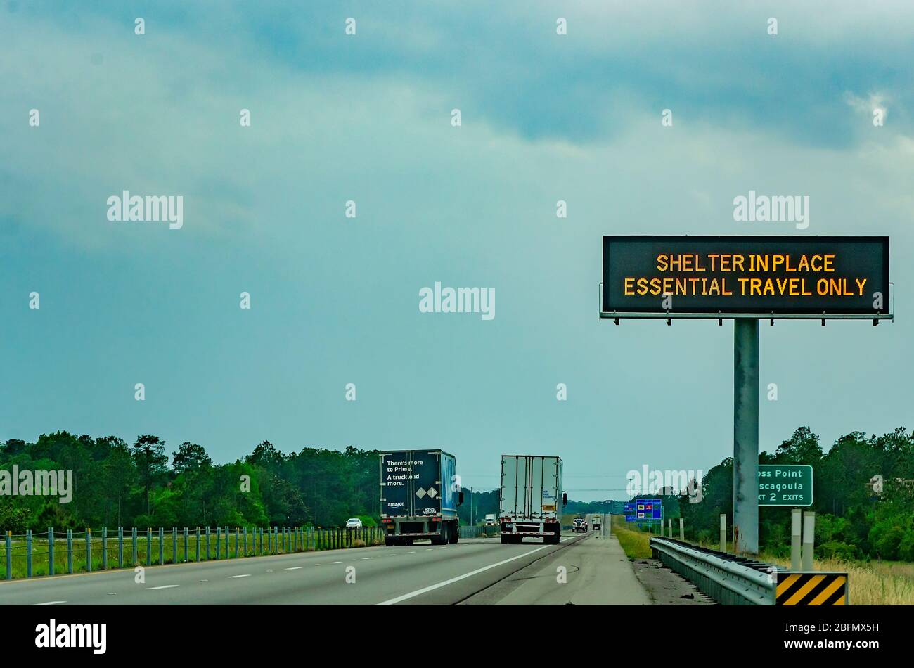 Semi trucks pass an electronic sign on Interstate 10 West warning motorists of Mississippi’s shelter in place order during the COVID-19 pandemic. Stock Photo