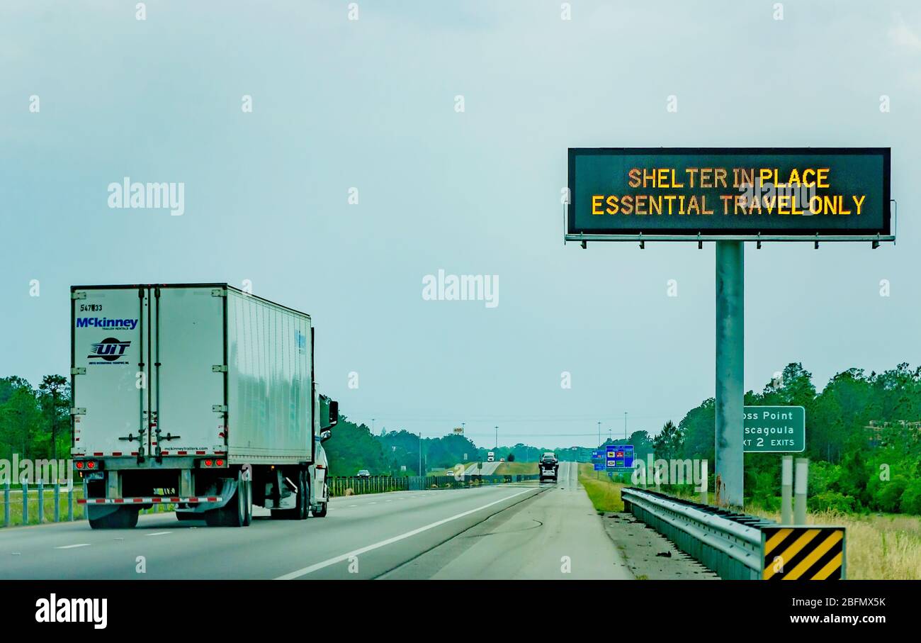 Semi trucks pass an electronic sign on Interstate 10 West warning motorists of Mississippi’s shelter in place order during the COVID-19 pandemic. Stock Photo