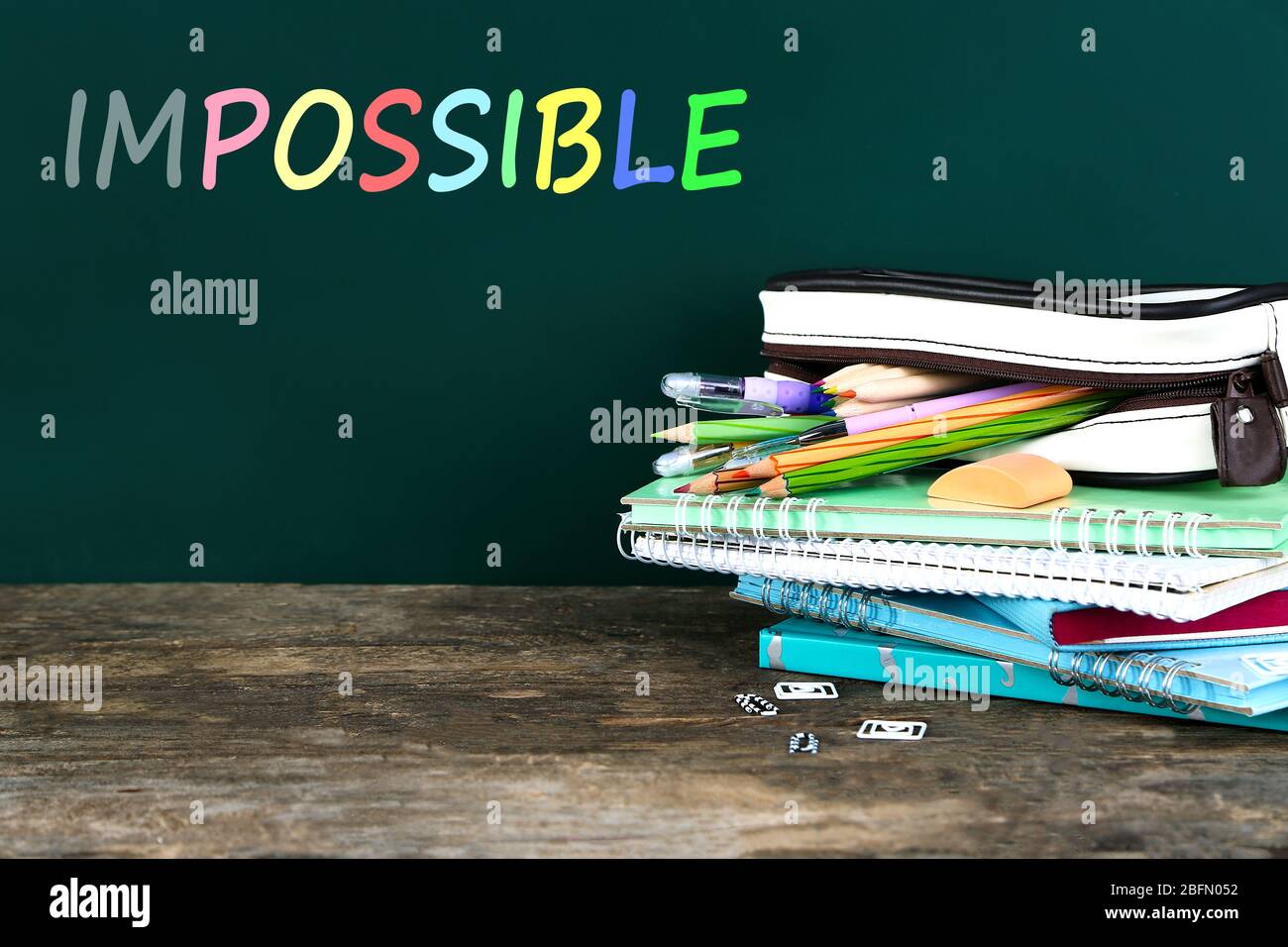 Word impossible transformed into possible on blackboard and textbooks Stock Photo