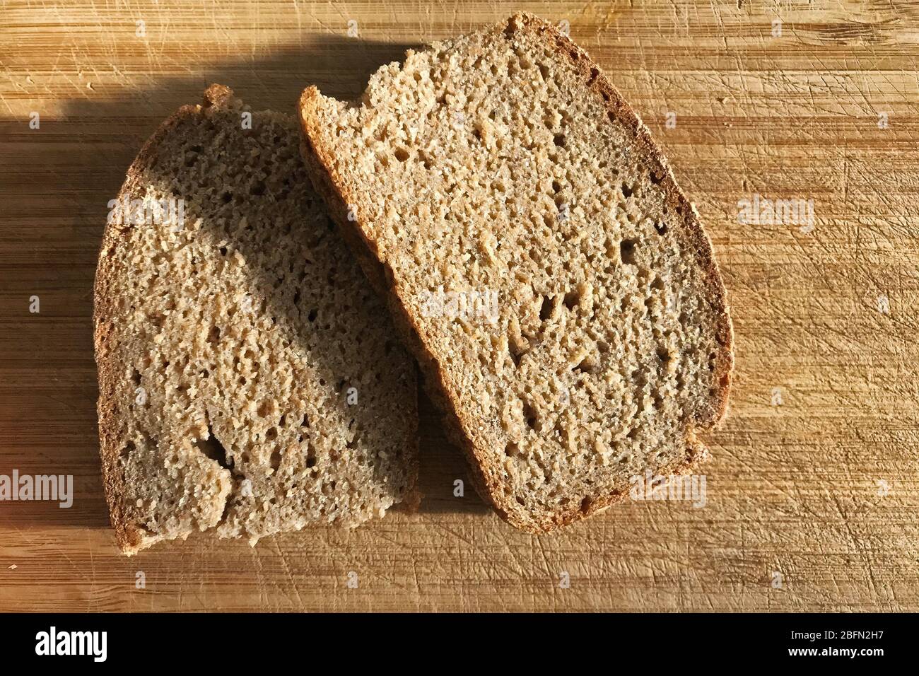 Two slices of rye bread lying on a wooden cutting Board. Stock Photo