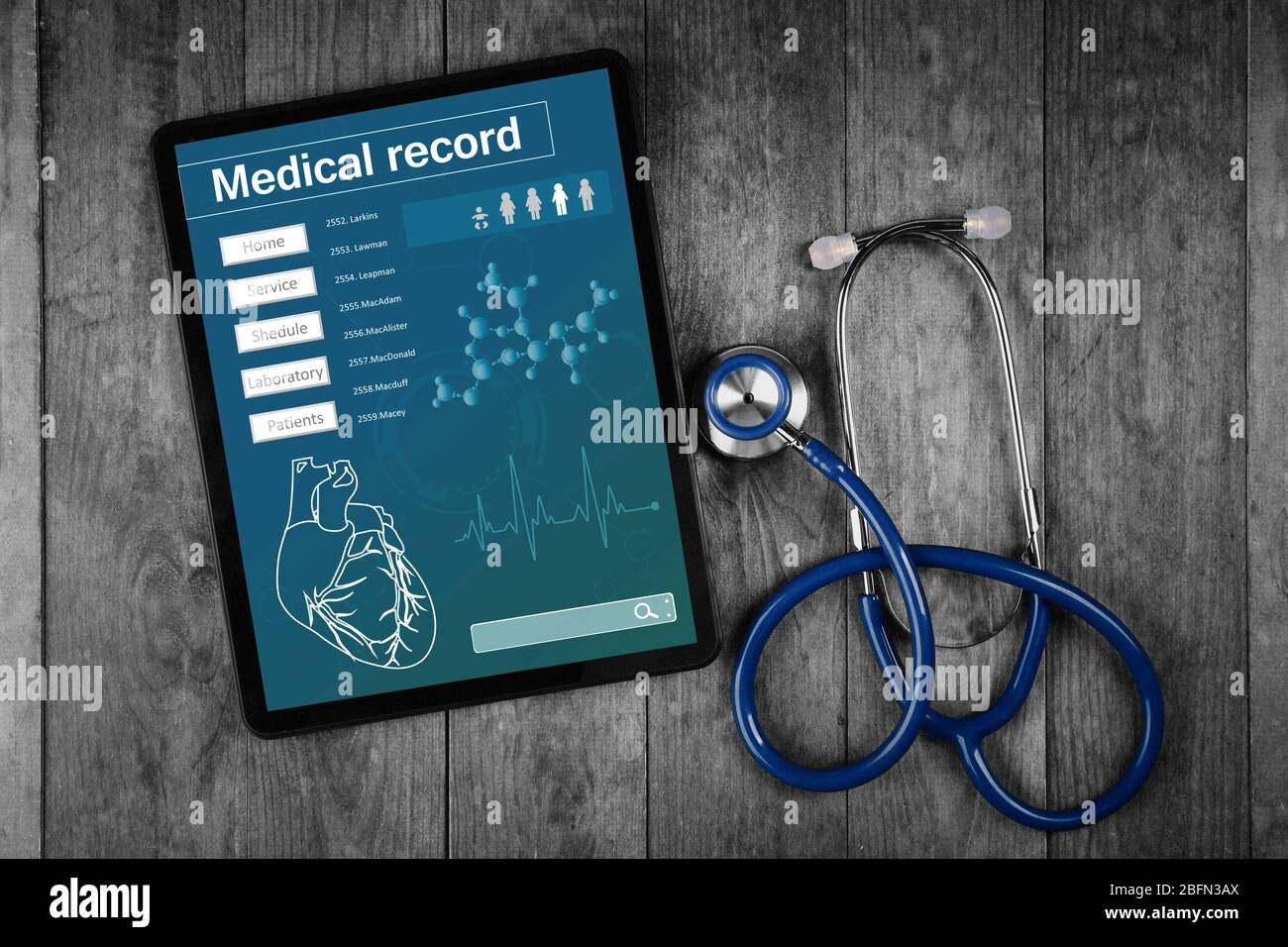 Medical record on tablet screen with stethoscope on wooden background