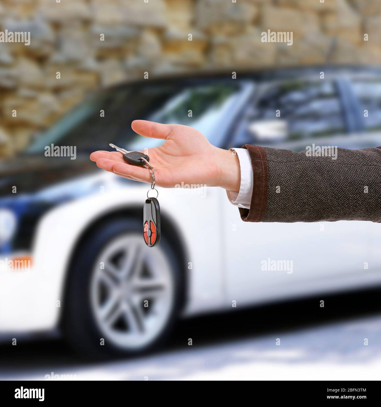 Male hand holding car keys on car background Stock Photo - Alamy