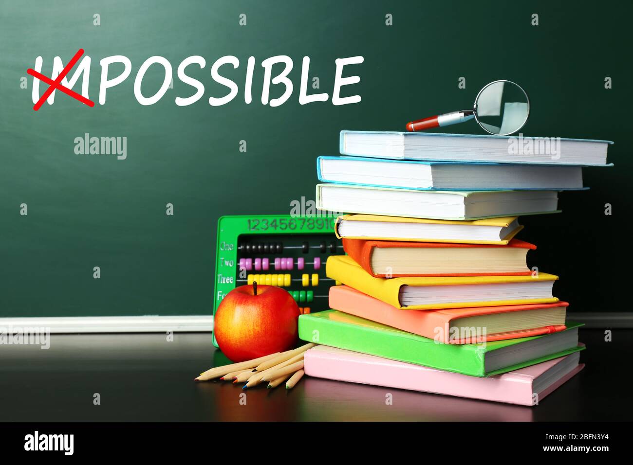 Word impossible transformed into possible on blackboard and textbooks Stock Photo