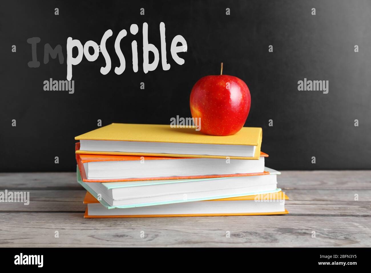 Word impossible transformed into possible on blackboard and textbooks Stock Photo
