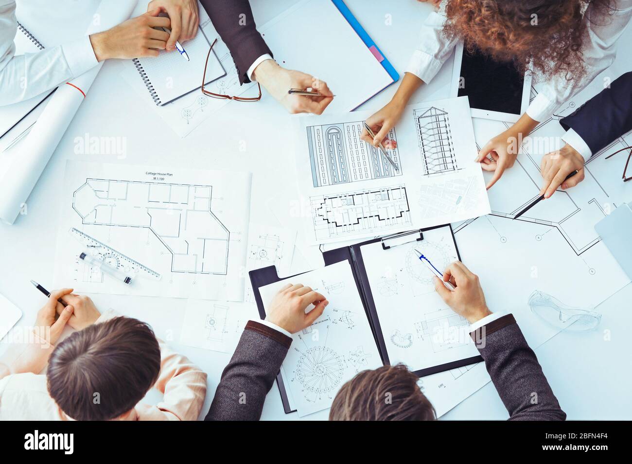 Team of professional engineers working with blueprints Stock Photo - Alamy