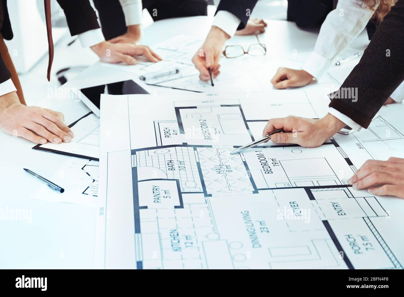 Team of professional engineers working with blueprints Stock Photo - Alamy