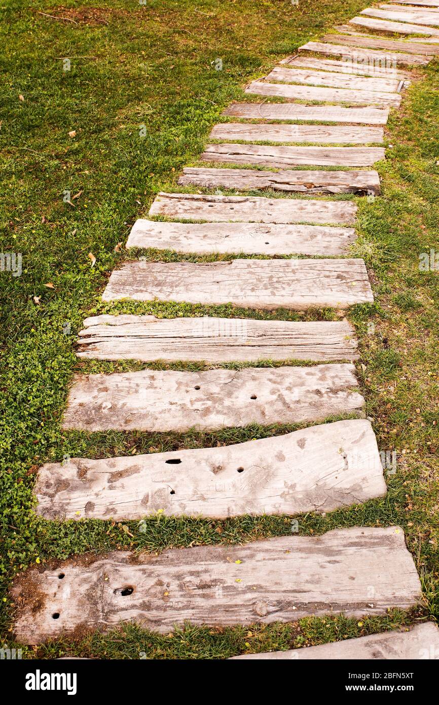 wooden pathway over the meadow to avoid stepping on the grass Stock Photo