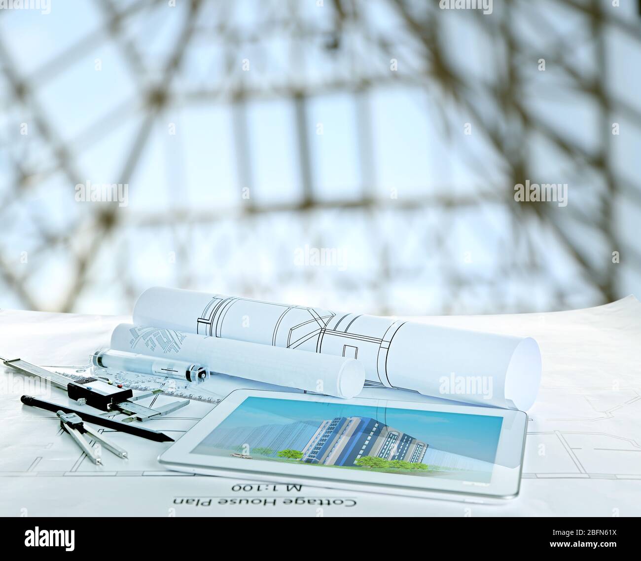 Table with construction drawings and other tools on blurred