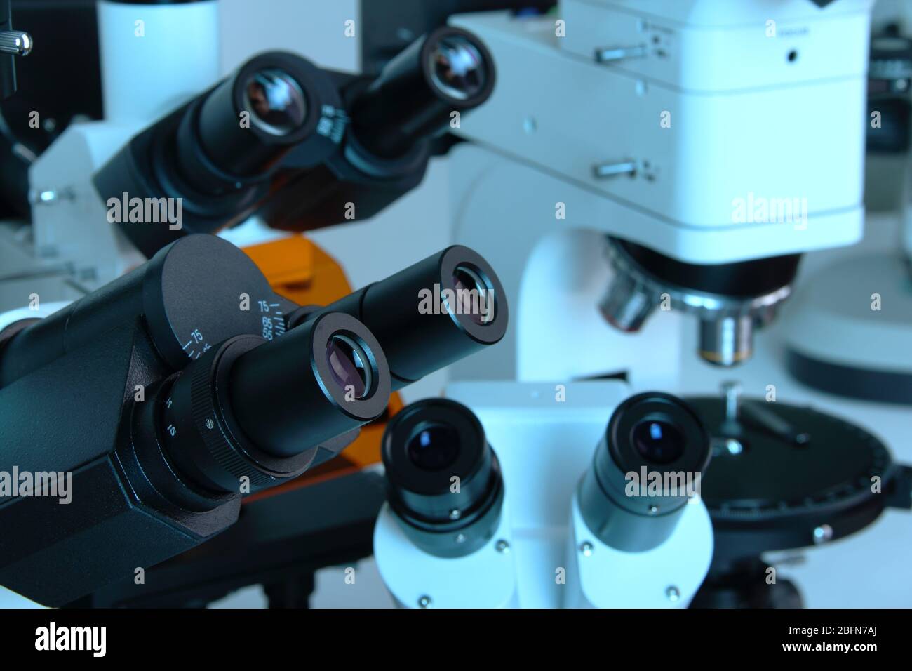 Group of various Microscopes in blue medicine light microbiology research concept Stock Photo