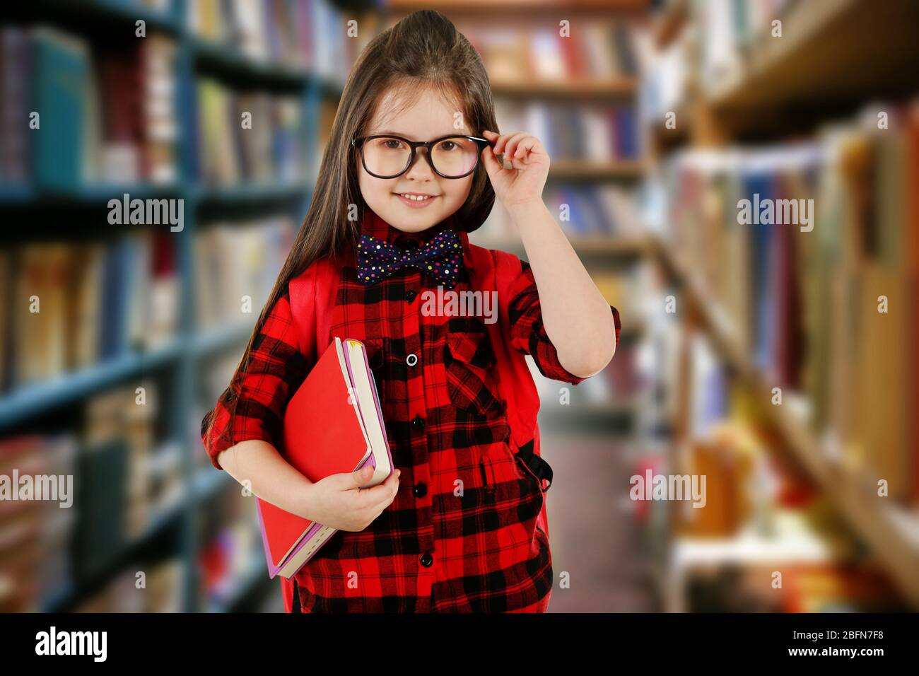 Girl with books in school library Stock Photo - Alamy