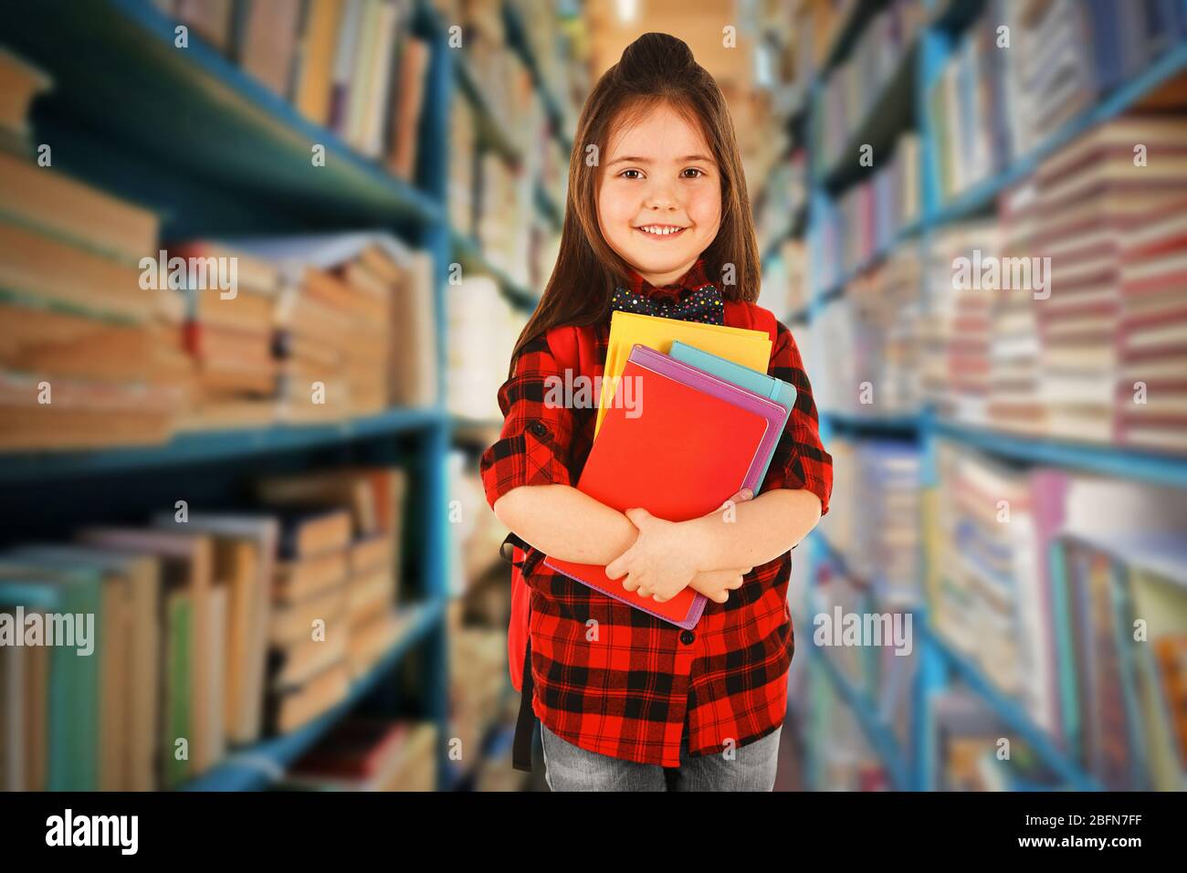 Girl with books in school library Stock Photo - Alamy