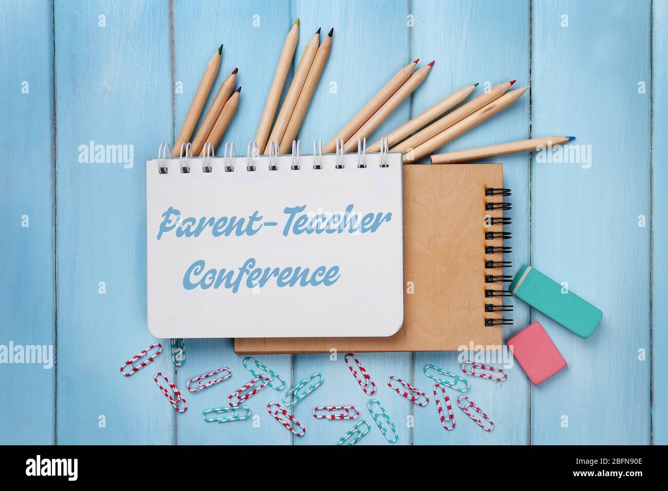 Text PARENT-TEACHER CONFERENCE written in notebook. Stationary on blue wooden background. School concept. Stock Photo