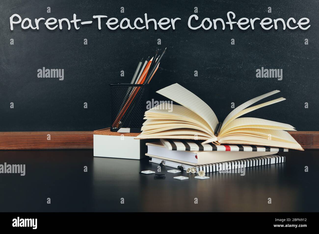 Stationary on table. Text PARENT-TEACHER CONFERENCE on blackboard background. School concept. Stock Photo