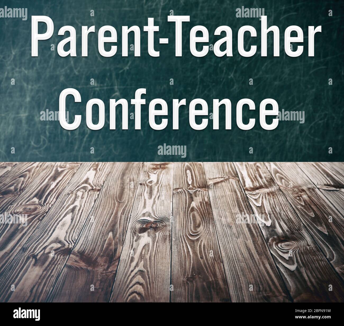 Wooden table against chalkboard. Text PARENT-TEACHER CONFERENCE on background. School concept. Stock Photo