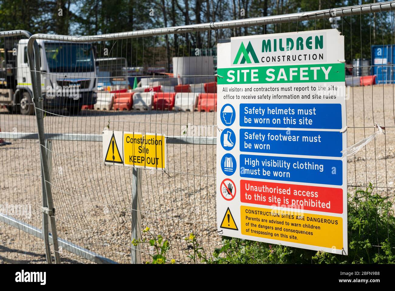 A site safety board on heras fencing at the entrance to a building site, empty with no construction work during the Covid 19 pandemic, April 2020, UK Stock Photo